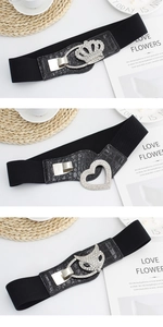 Detailed close-up of crystal-encrusted crown and heart buckles on wide elastic belts