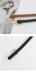 Close-up of narrow leather belts with gold triangle buckles and coin for size scale
