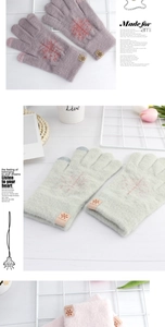 Detail of snowflake pattern warm knit gloves with touchscreen tips and leather logo patch