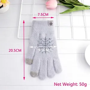 Purple touchscreen knitted winter gloves with snowflake pattern on white wood background