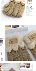 Close-up of cute leopard paw knitted gloves with leather claws and round boy patch
