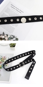 Détail de la ceinture en toile noire avec doubles œillets et boucle ronde argentée