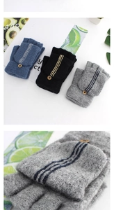 Detail of striped knitted flip-top gloves with vintage button and navy gray black textures