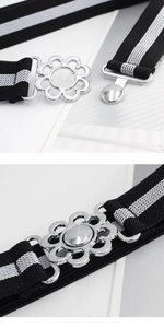 Detail of elastic waist belt with black and white stripes and silver floral buckle