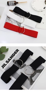Detail view of elastic waist belt with large silver round metal buckle and multi-color bands