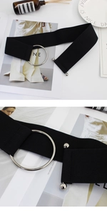 Detail of black elastic waist belt with silver metal ring buckle and decorative sphere