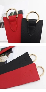 Detalle de correas de cuero rojo y negro con anillos dorados y textura de cuero lichi