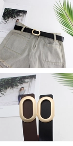 Close-up of golden oval buckle on minimalist leather belt with light grey denim shorts