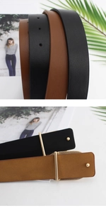 Detailed close-up of smooth black and brown leather belts with minimalist gold buckles