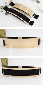 Detail of black elastic wide belts with gold mirror metal plates and buckle closure