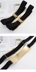 Detail of mirror-polished gold metal buckle on a black elastic wide waist belt