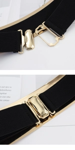 Detailed close-up of a wide elastic black belt featuring a gold geometric metal buckle