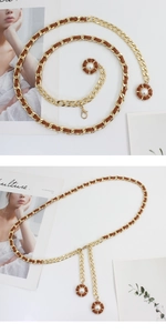 Detail of gold metal and brown leather woven waist chain with pearl flower pendants
