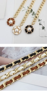 Detail of woven leather chain belt with camellia flower and pearl charm pendant