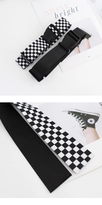Gros plan de ceintures en nylon avec boucle en plastique et motif en damier noir et blanc