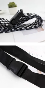 Vue détaillée des ceintures en toile tissée noires et à damier avec boucles
