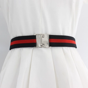 Unisex elastic striped belt with silver buckle on a white dress for styling