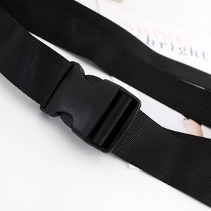 Ceinture en nylon noir pour femmes avec boucle en plastique mat sur fond blanc minimaliste