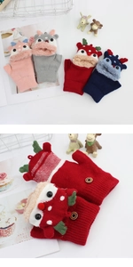 Detail of knitted deer gloves with flip top design and wooden fashion button