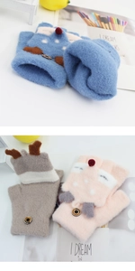 Close-up of children's knitted mittens with reindeer design and button details