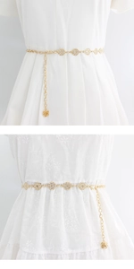 Vue détaillée d'une ceinture chaîne dorée avec strass scintillants et pendentif rose