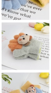 Detailed plush texture of colorful toddler gloves featuring 3D cartoon bear designs