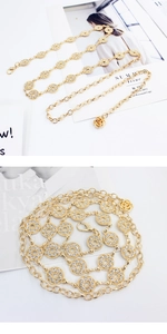 Détail de la ceinture chaîne dorée élégante avec strass brillants et pendentif rose