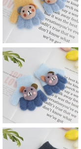 Detailed view of knitted toddler gloves featuring 3D plush bear charms in various colors