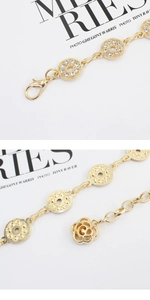 Détail de la ceinture chaîne dorée avec anneaux en strass et pendentif rose élégant