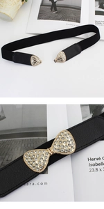 Detail of black elastic waist belt featuring a rhinestone-encrusted triangular metal buckle