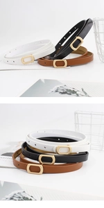 Close-up of slim women belts in black, white, and brown with golden oval buckles