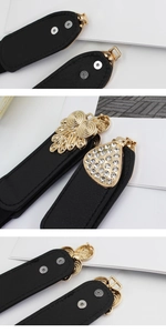 Detail of vintage gold metal buckles with rhinestones and scrollwork on black elastic belt