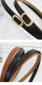 Close-up of matte champagne gold oval buckle on minimalist lychee grain leather belts
