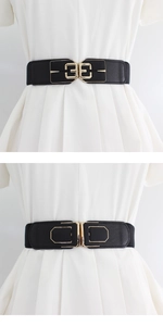Detail of two black elastic waist belts with geometric interlocking golden metal buckles