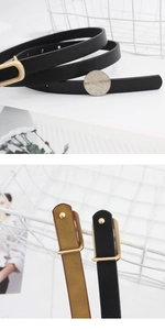 Detail of slim black and brown belts with gold buckles and coin for size scale