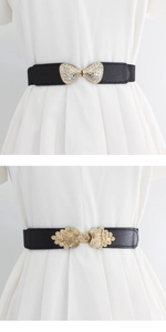 Detail of black elastic waist belts with rhinestone bow and vintage golden metal buckle