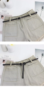 Detail view of high-waist denim shorts featuring a slim black leather belt and frayed hems