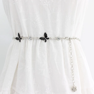 Elegant silver butterfly waist chain belt with floral pendant on white lace dress
