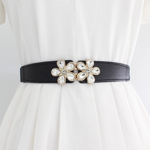 Elastic black waist belt for women featuring dual floral rhinestone buckles on a dress