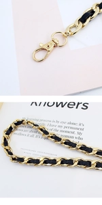 Detailed macro view of golden metal chain with black leather strap and lobster clasp