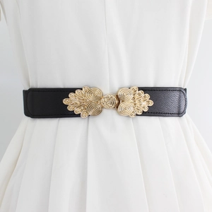 Women's black elastic waist belt with vintage gold filigree buckle on white dress