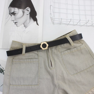 Short en jean clair pour femme avec une ceinture noire fine et une boucle fleurie dorée