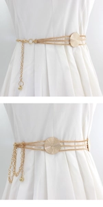 Detail view of a gold multi-layer chain waist belt with sunburst texture round metal charm