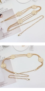 Detail of adjustable golden multi-layer metal chain belt with embossed round discs