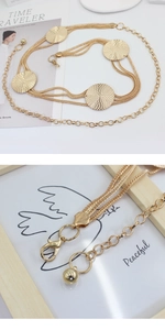 Macro detail of gold metal chain waist belt with textured circular plates and lobster clasp