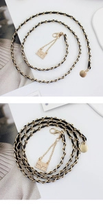 Detail of gold metal and black leather woven chain belt with quilted mini bag charm