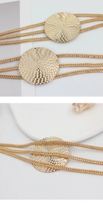 Detailed macro view of golden metal chain belt featuring textured circular discs and links
