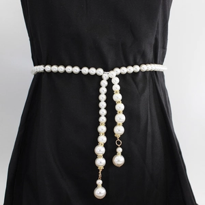 Chaîne de taille en perles élégante avec glands et détails dorés sur robe noire