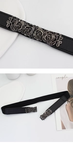 Detail of vintage silver rose metal buckle on a black elastic waist belt for women