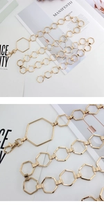 Detail view of a gold hexagonal link waist chain with a lobster clasp closure and high gloss finish